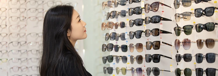 A person looking at a wall of frames.